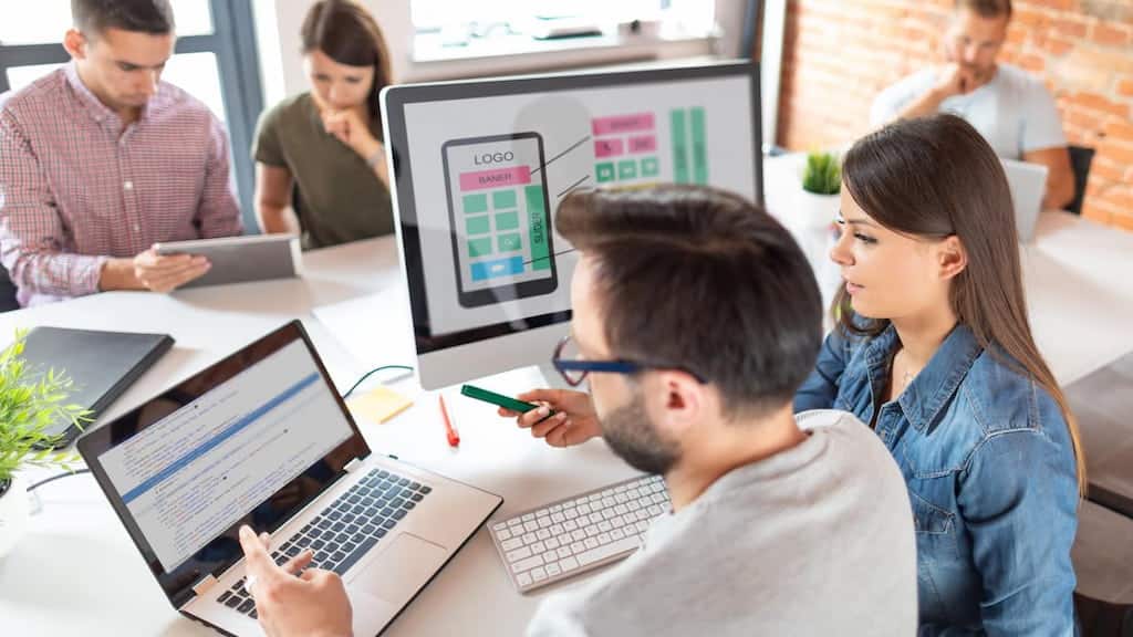 An app development team discussing a custom mobile UI/UX